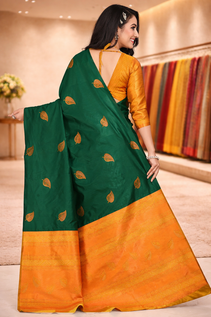 Back view of a dark green silk saree showing the detailed golden zari pallu and mustard matching blouse.